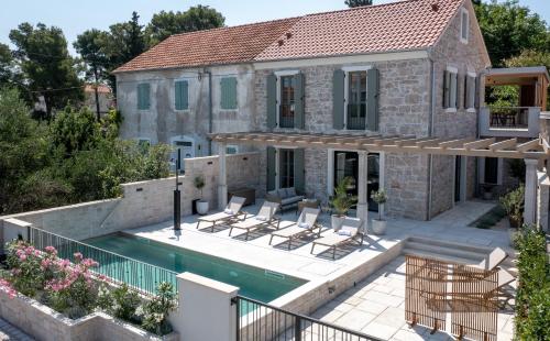 a home with a swimming pool and a house at Heritage Villa Francheza-Elegant Stone villa near the Beach, Pašman Island , Ugrinić in Ugrinići