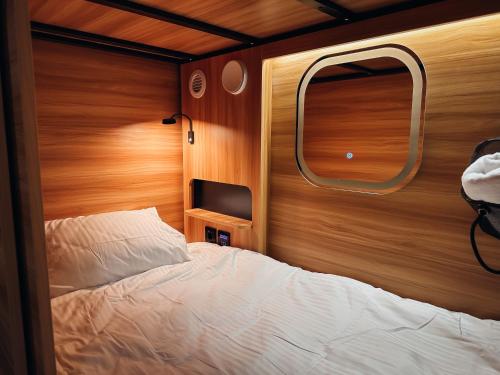 a small bedroom with a bed and a window at Central Hostel Lesce-Bled in Lesce