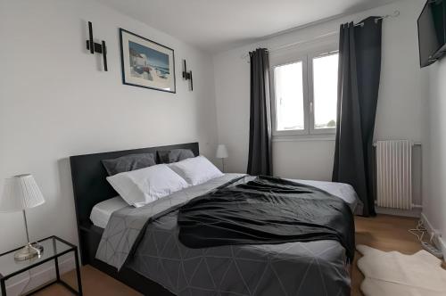une chambre avec un grand lit et une fenêtre dans l'établissement 3 pièces lumineux, balcon & parking - Paris 20 min, à Sartrouville