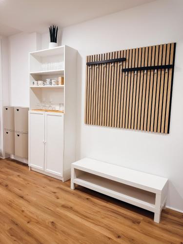 a white room with a bench and a shelf at Central Hostel Lesce-Bled in Lesce
