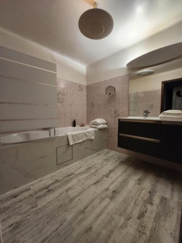 une salle de bain avec une baignoire, un lavabo et un miroir dans l'établissement Hôtel La Fuste, à Valensole