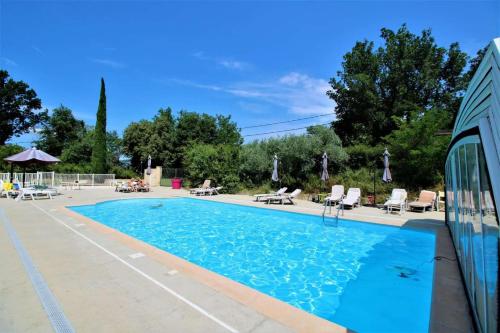 une grande piscine avec des chaises dans l'établissement Hôtel La Fuste, à Valensole