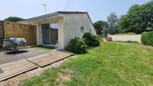 a small house with a patio and a yard at Appartement cosy avec jardin in Meauzac