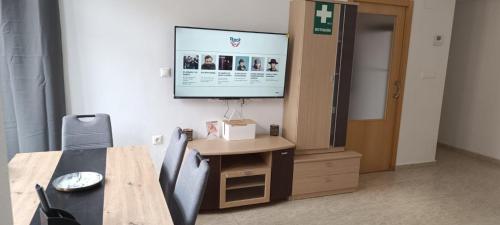 a room with a table and a television on a wall at Apartalux San Pedro Mar in San Pedro del Pinatar