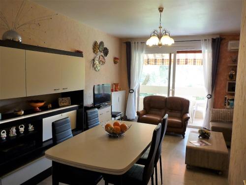 une cuisine et un salon avec une table et des chaises dans l'établissement agréable appartement 3 pièces 62 m2, à Hyères