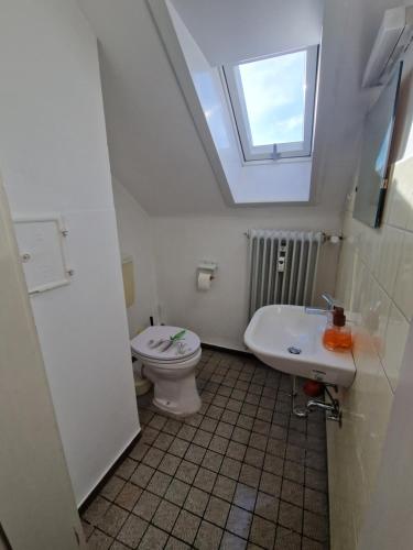 a bathroom with a toilet and a sink and a window at Residencia del Pueblo II in Pirk