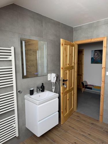a bathroom with a white sink and a mirror at Penzion Pod pecí in Lenora
