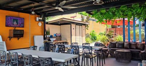 un patio con tavoli, sedie e divano di Exclusive Beachfront House with Pool Batangas 16pax a Lobo