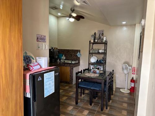 una camera con tavolo e una cucina con frigorifero di Exclusive Beachfront House with Pool Batangas 16pax a Lobo