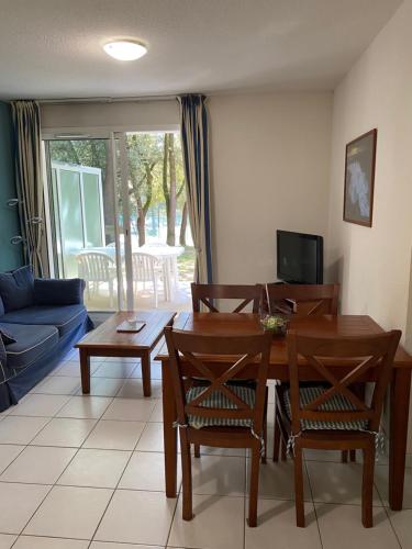 un salon avec une table et des chaises en bois dans l'établissement Appart T2 avec coin séparé 2 lits superposés Domaine KER JULIETTE, à Pornichet