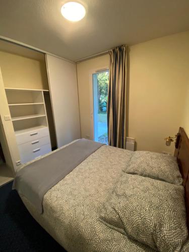 une chambre avec un lit et une fenêtre dans l'établissement Appart T2 avec coin séparé 2 lits superposés Domaine KER JULIETTE, à Pornichet