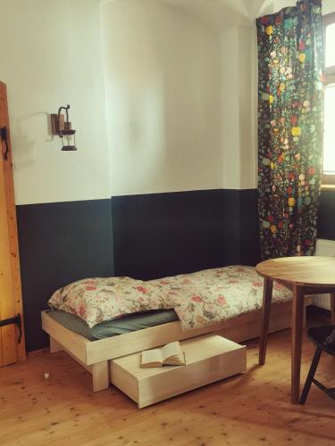 a bed in a room with a table and a bed with a bed frame at Bergmanns Lieblingsplatz in Freiberg