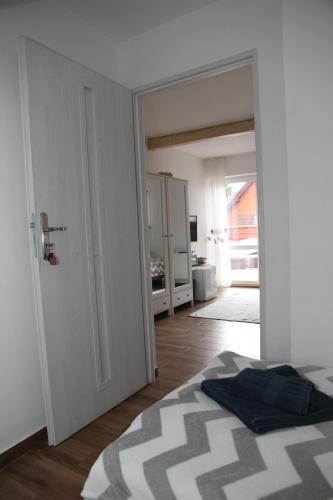a bedroom with a bed and a door to a kitchen at Pensjonat E&M in Mikołajki