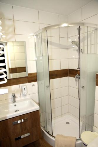 a bathroom with a shower and a sink at Pensjonat E&M in Mikołajki