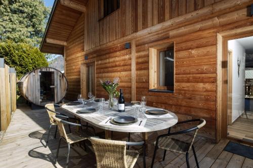 une table sur une terrasse avec une bouteille de vin dans l'établissement Chalet La Bise, à Morzine