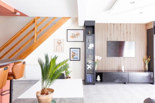 a living room with a tv and a staircase at Loft tout confort avec parking et à moins 15 min Caen et des Plages in Démouville