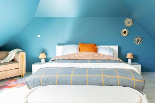 a blue bedroom with a bed and a blue wall at Loft tout confort avec parking et à moins 15 min Caen et des Plages in Démouville
