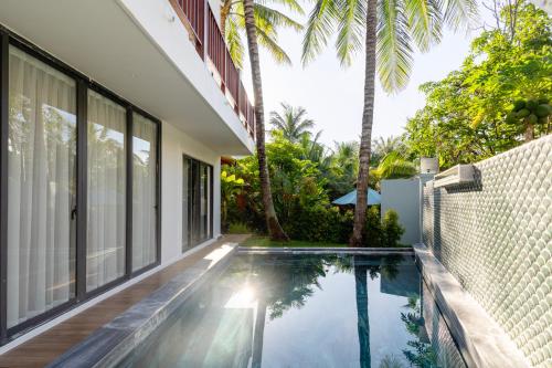 an external view of a house with a swimming pool at Shoreline Stay in Hoi An