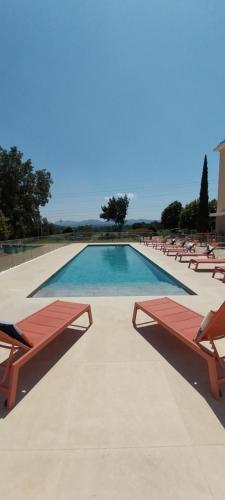 a swimming pool with chairs and a swimming pool at ibis Styles Cabriès Aix-en-Provence TGV in Cabriès