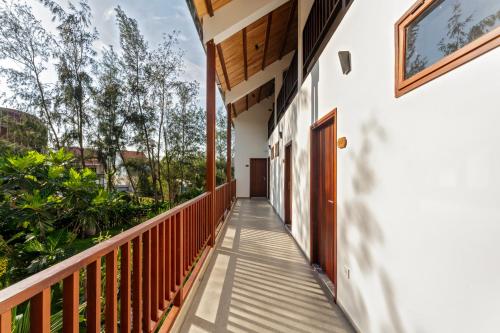 a balcony of a house with a door and trees at Shoreline Stay in Hoi An