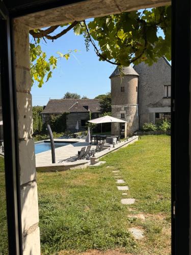 - une vue sur une cour avec une piscine et un bâtiment dans l'établissement Meublés de Charme Romantique en Touraine, à Fondettes