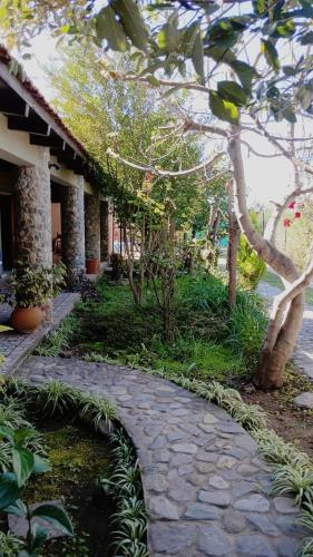 a stone walkway in front of a building with plants at Cabañas Los Lapachos in Chicoana
