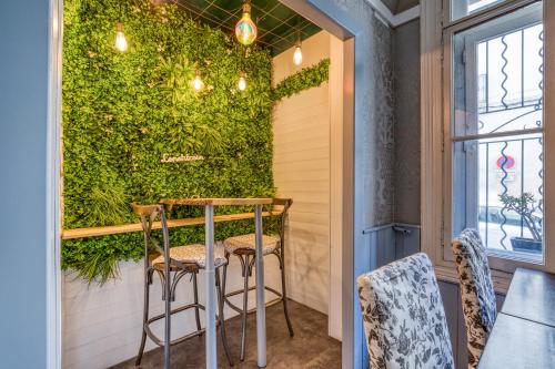 a room with a green wall and stools at Hôtel Mistral Comédie Saint Roch in Montpellier