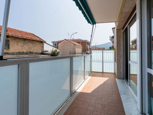 ein Balkon mit Glastüren und Blick auf ein Gebäude in der Unterkunft Apartment Happiness by Interhome in Loano