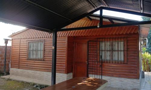 awning over a wooden building with a wooden door at Cabañas Los Lapachos in Chicoana