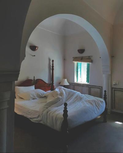 a bedroom with a large bed with an archway at Mandawa Kothi in Mandāwa