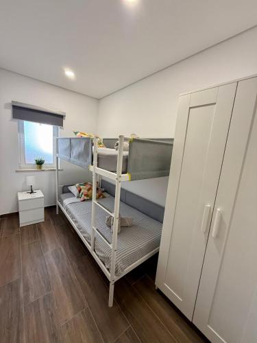 a room with two bunk beds and a cabinet at Tomasoni summer house in Armação de Pêra