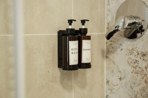 two bottles of soap on a wall in a bathroom at Good Vibes apartment centro storico Reggio Emilia in Reggio Emilia