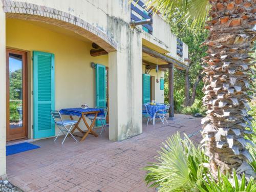 a patio with blue doors and a table and chairs at Holiday Home L'Aietta di Maciarello by Interhome in SantʼAndrea