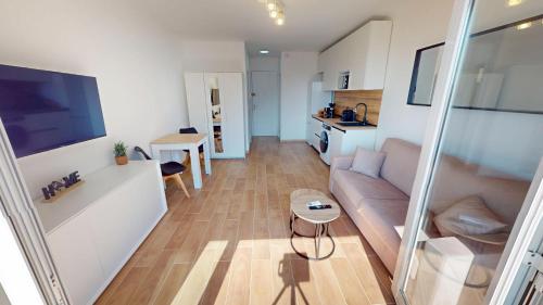 ein Wohnzimmer mit Sofa und Tisch in der Unterkunft Superbe studio climatisé entièrement rénové au 5ème et dernier étage sur le bord de Mer de Menton in Menton