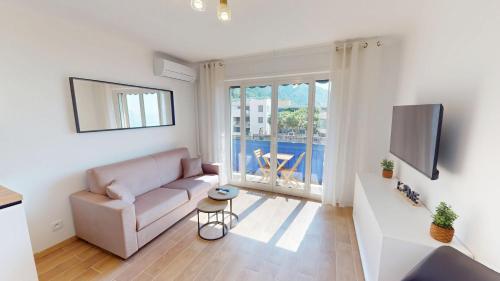 un salon avec un canapé et une télévision dans l'établissement Superbe studio climatisé entièrement rénové au 5ème et dernier étage sur le bord de Mer de Menton, à Menton
