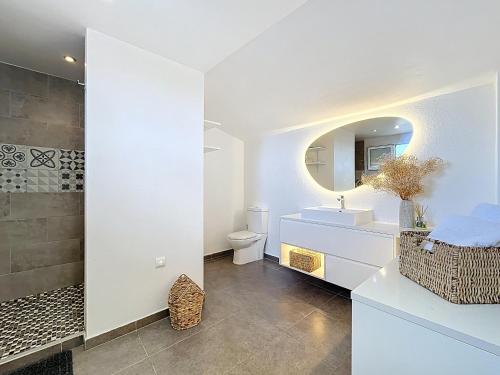 une salle de bain avec un lavabo, des toilettes et un miroir dans l'établissement Villa Fautea Romance, à Fautea