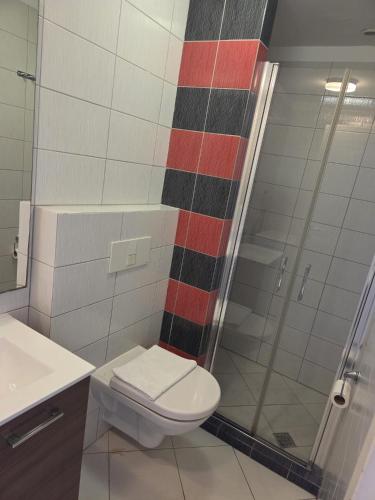 a bathroom with a toilet and a glass shower at Kristal Paris Resort in Novalja