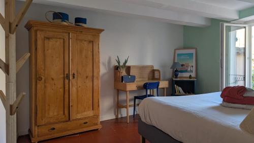 - une chambre avec une armoire en bois à côté d'un lit dans l'établissement Charming & medieval village house completely renovated with great exterior and views, à Mallemort