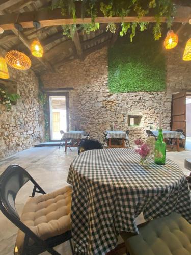 a room with a table and chairs and a stone wall at Casa Rural Casa Selmo in Carreno