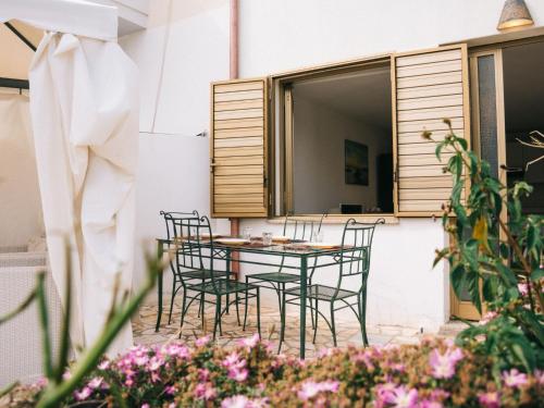 een tafel en stoelen op een patio met bloemen bij Apartment Wendy by Interhome in Santa Maria Navarrese