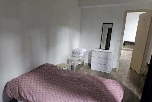 une chambre avec un lit, une commode et un miroir dans l'établissement Grand appartement proche centre ville, à Digne-Les-Bains