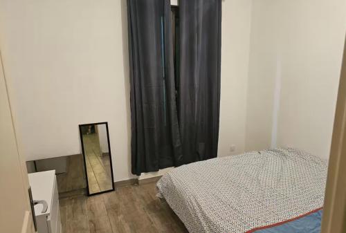 une chambre avec un lit, un miroir et une fenêtre dans l'établissement Grand appartement proche centre ville, à Digne-Les-Bains