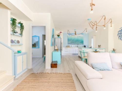 a living room with a white couch and a kitchen at Villa Tiffany by Interhome in Punta Ala