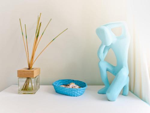 a blue figurine next to a blue bowl and a plant at Villa Tiffany by Interhome in Punta Ala