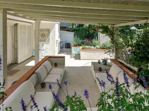 a patio with white furniture and purple flowers at Villa Tiffany by Interhome in Punta Ala