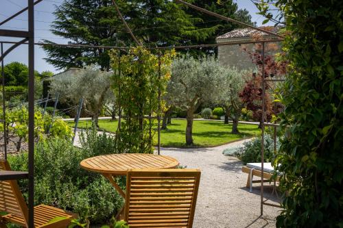 a table and chairs in a garden with trees at Mas des Cèdres in Ménerbes