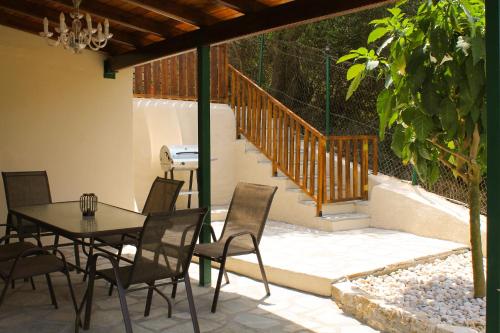 a patio with a table and chairs and a staircase at Villa Parselina in Ágios Ilías