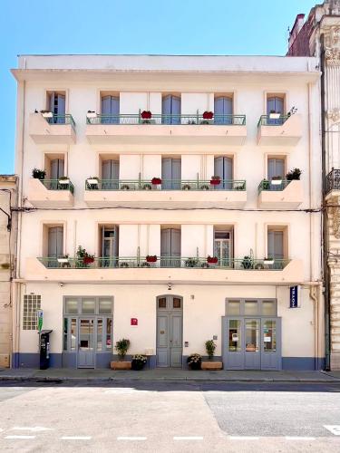 a large white building with windows and balconies at Le National Sète Centre Gare,Ascenseur in Sète