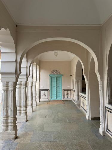 a hallway with a turquoise door in a building at Mandawa Kothi in Mandāwa