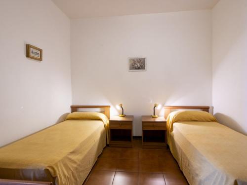 two beds in a room with two lamps on tables at Apartment Edo by Interhome in Trarego Viggiona